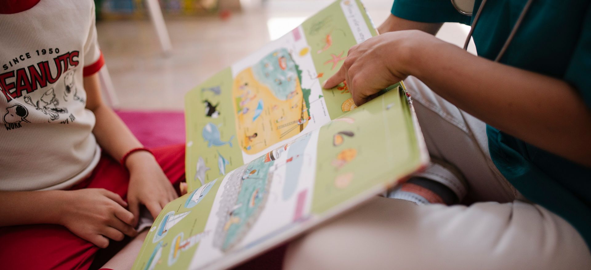 An adult and child sharing a picture book.